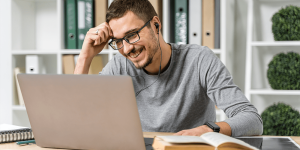 medium-shot-smiley-guy-studying-with-his-laptop-min medium-shot-smiley-guy-studying-with-his-laptop-min